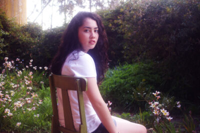 Photography by Alara Baldwin, Alexandra Phillips, Chelsea Hillas, Emily Kalafatis, Furat Alsabti, Gabbie Cirillo, Georgie Evans, Lauren Minicozzi, Margot Craig, Melanie Nixon, Mikaela Cowan, Natalie Sakarintr, Paul Prato, Rebecca Brun and Sarah Mitchell, Year 10, Goulburn Valley Grammar School Student photograph of a girl sitting in a garden